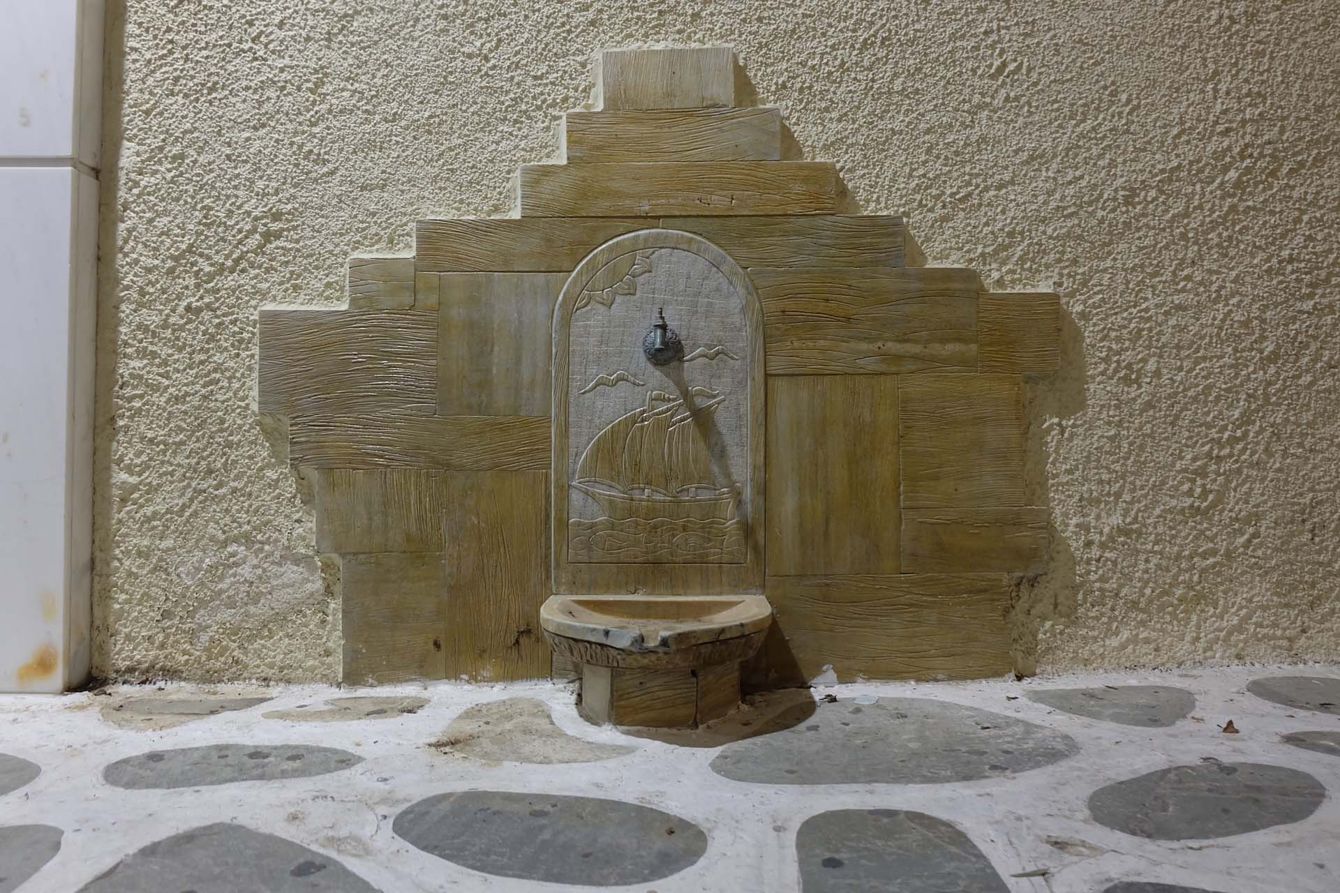 Ein dekorativer steinerner Trinkbrunnen in den Gassen der Altstadt